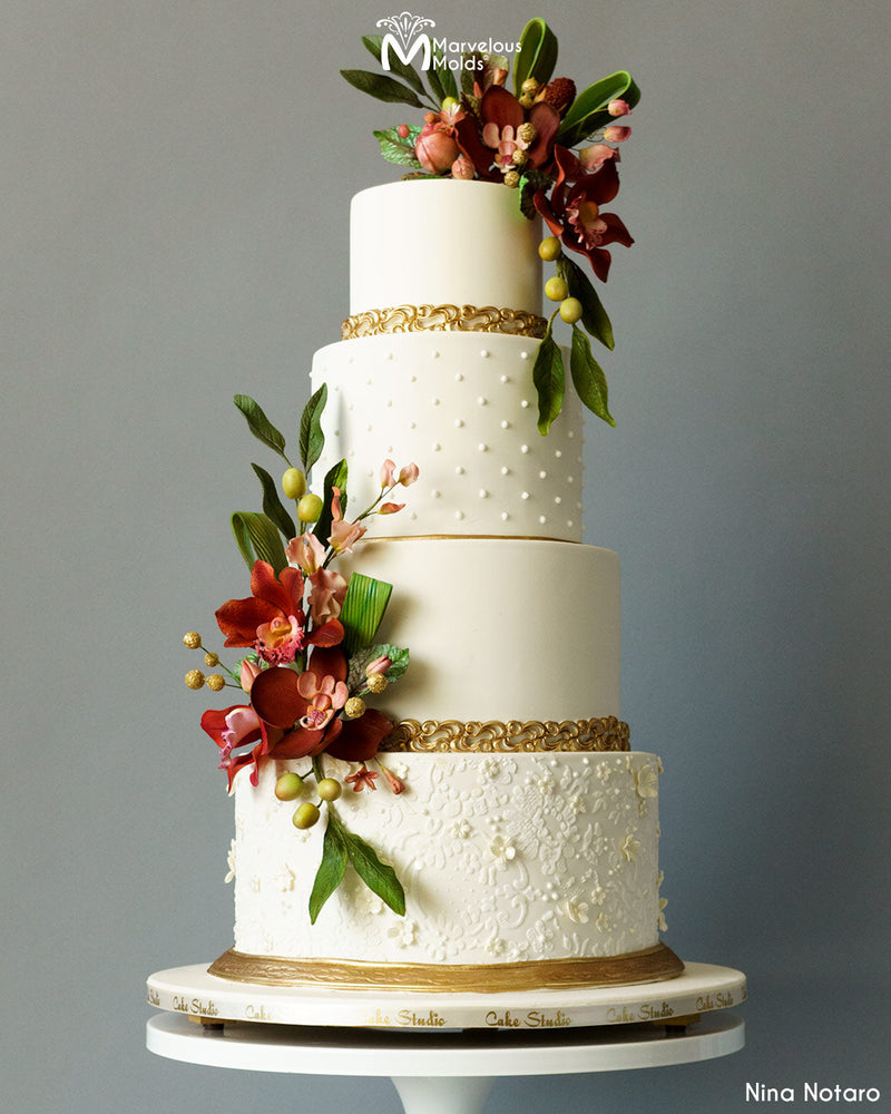 White wedding cake with a golden border designed using the Marvelous Molds Brava Border Mold