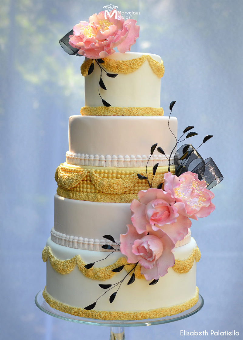 Whtie Wedding Cake with Yellow Borders and Details Decorated with the Floral Swag Silicone Mold by Marvelous Molds