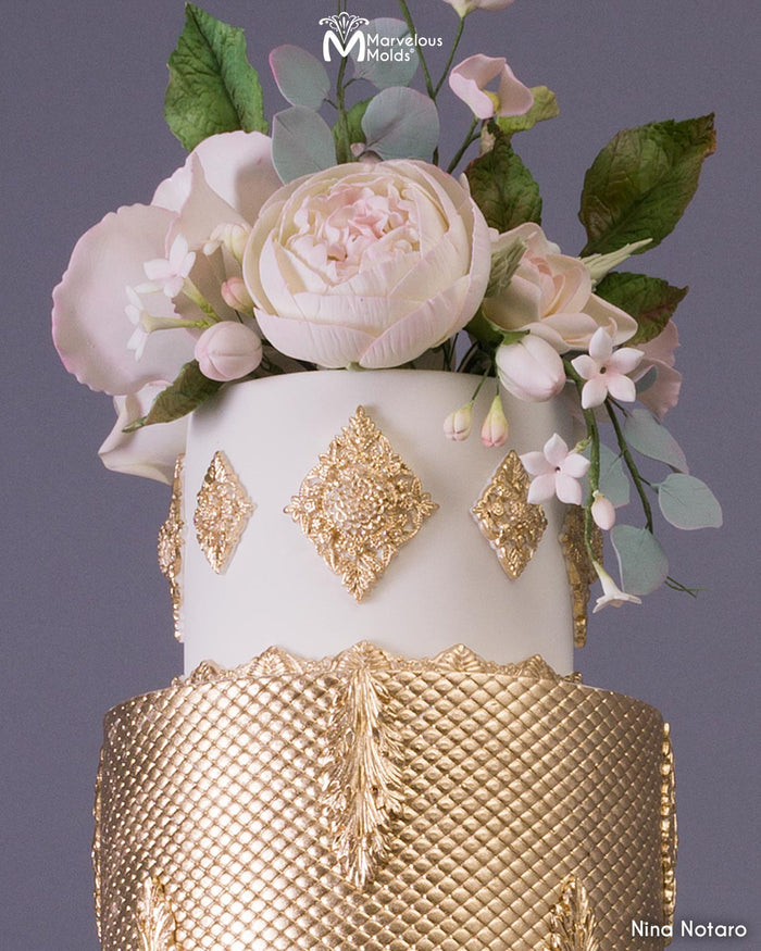 Gold and White Wedding Cake Close Up Displaying Gold Embellishments, Decorated Using the Marvelous Molds Crescendo Border Silicone Mold